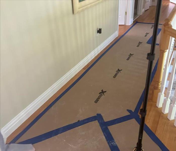 hallway hardwood floor covered with blue tape and plastic